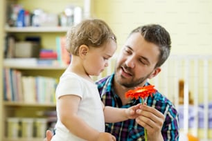 Ritratto di un padre felice con il fiore e la sua piccola figlia