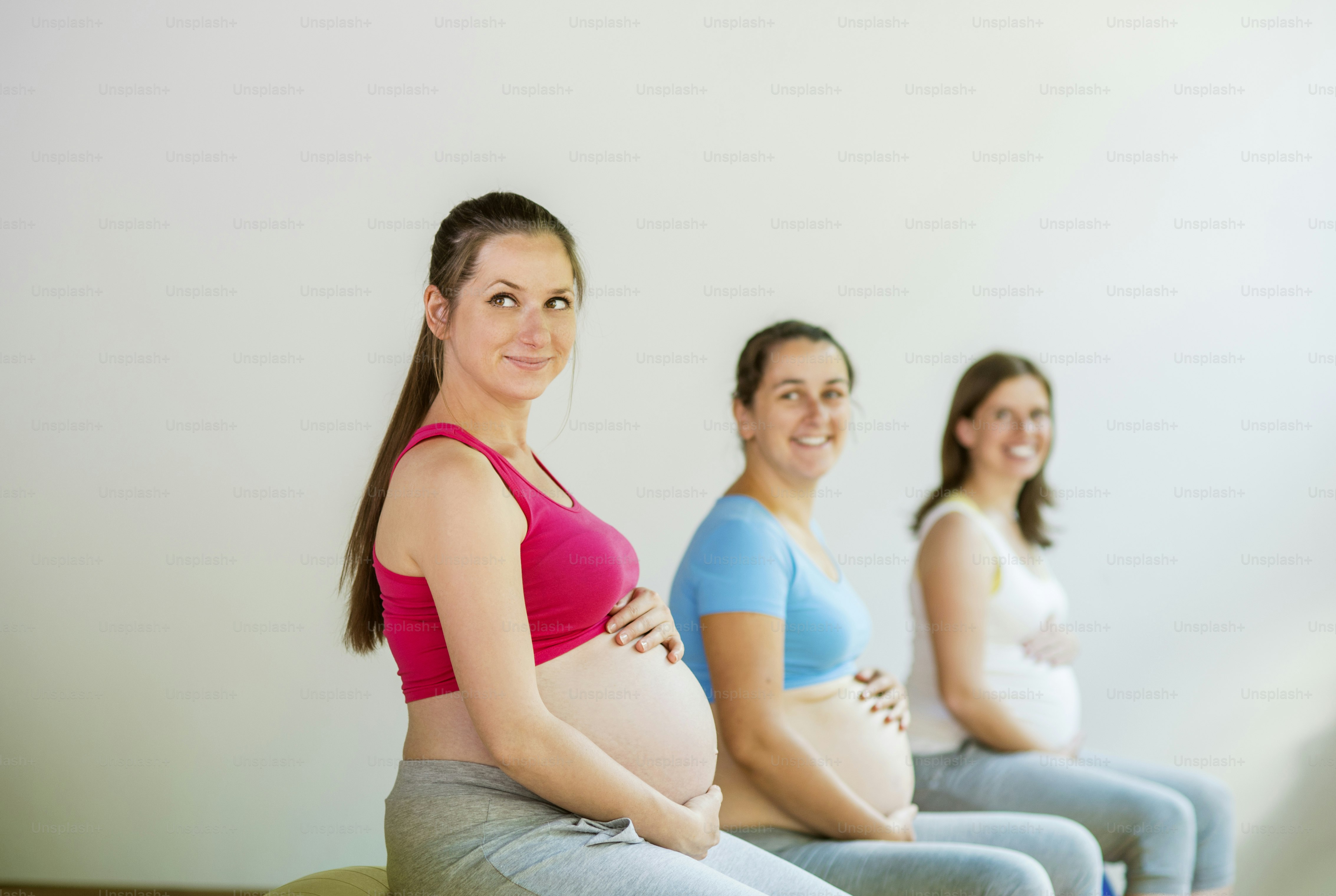 Young pregnant women doing exercise using a fitness ball