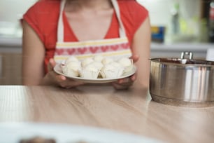 Woman is making christmas cakes in the kitchen