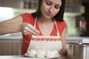 Woman is making christmas cakes in the kitchen