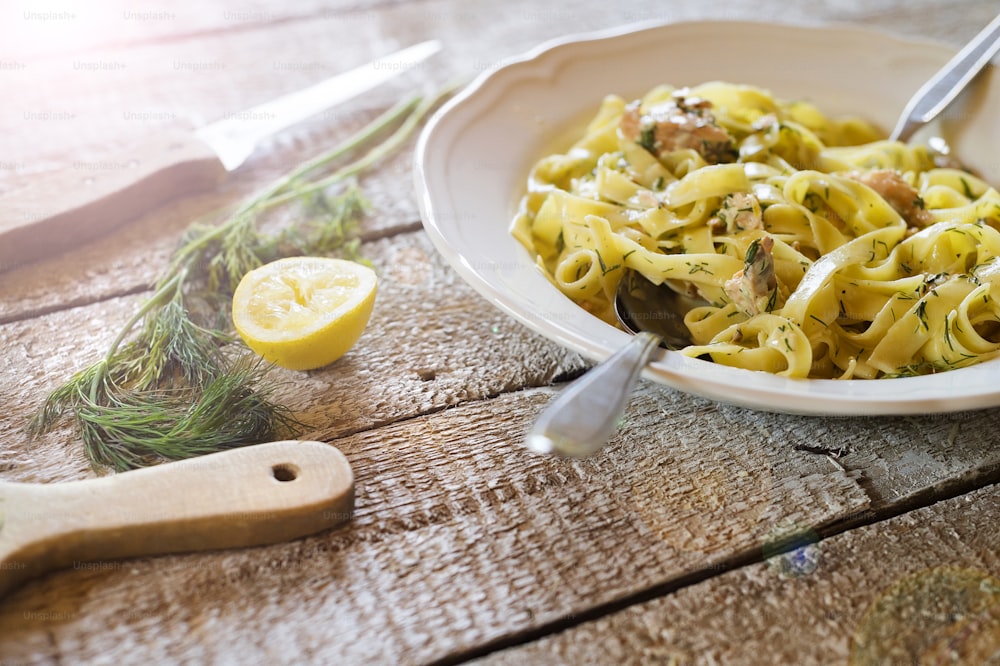 Salmon tagliatelle on a plate on wooden kitchen table