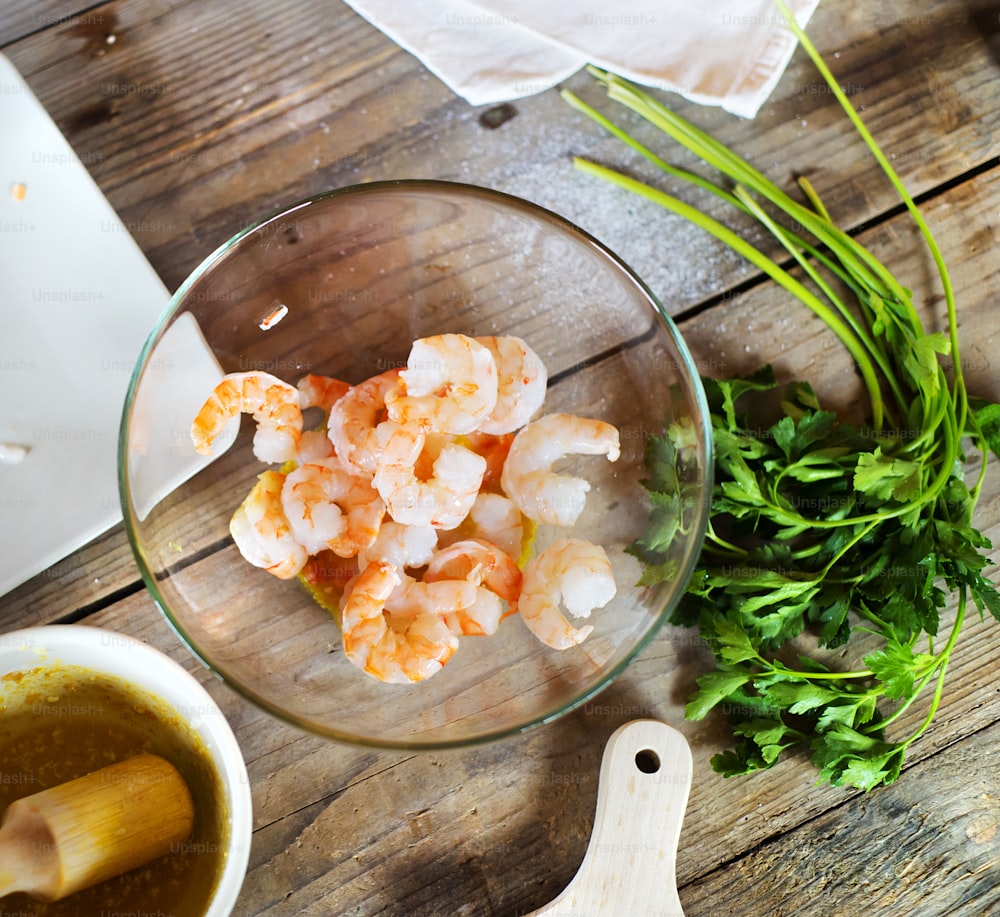 Prawns and other ingredients for dinner. Studio shot on wooden table background.