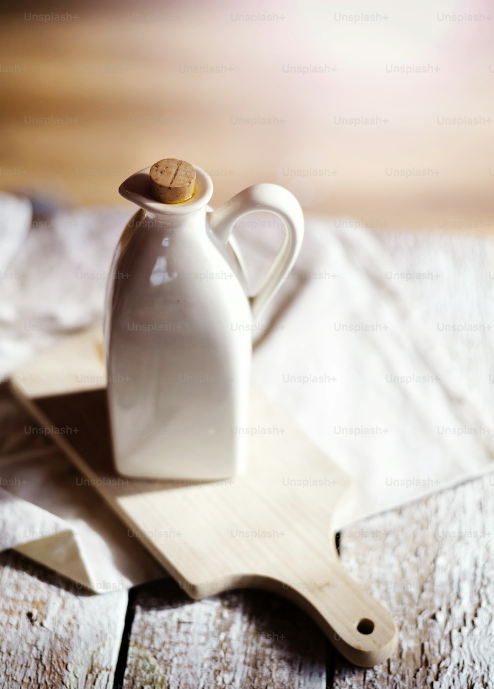 Olive oil in ceramic jug on a wooden table