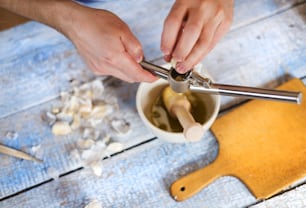 Man in the kitchen using a garlic press
