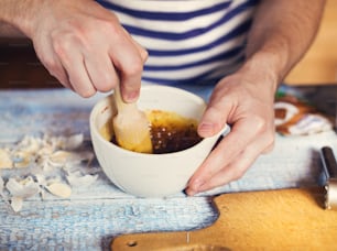 Man in the kitchen mixing together ingredients for a dressing