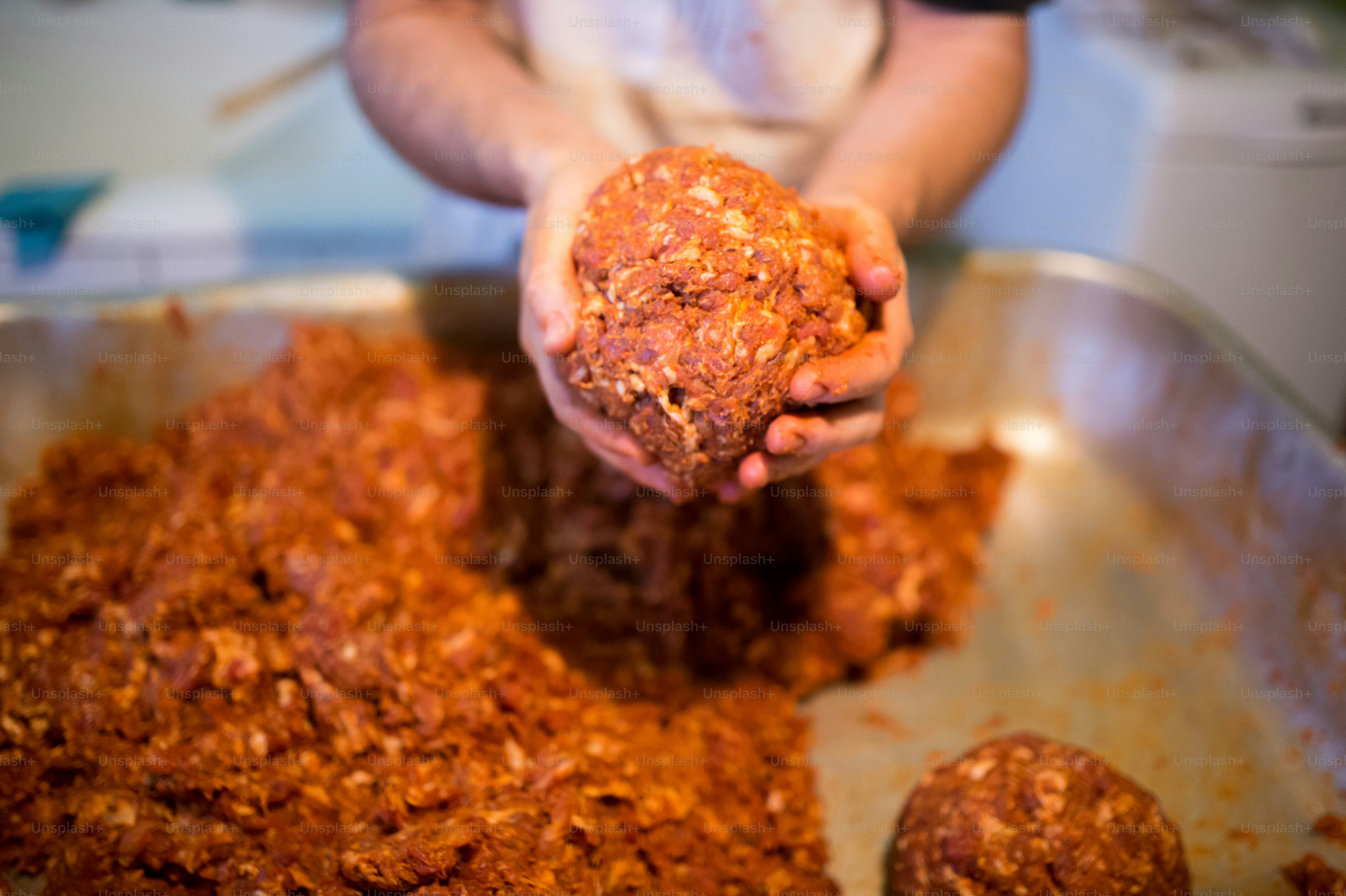 Unrecognizable man making sausages the traditional way at home. Holding ...