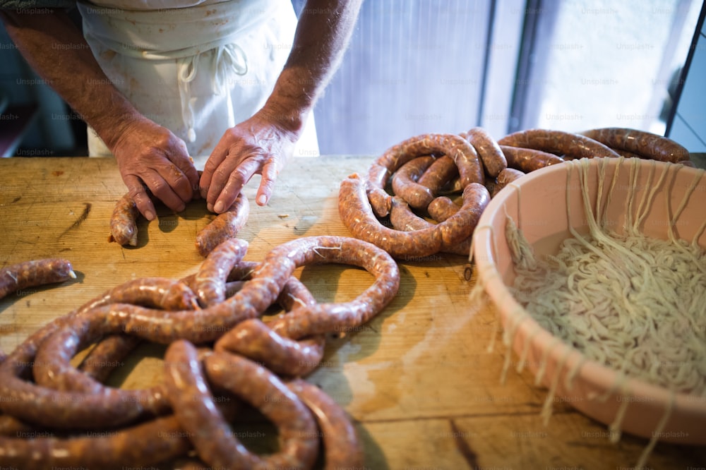 Unrecognizable man making sausages the traditional way at home. Close up.