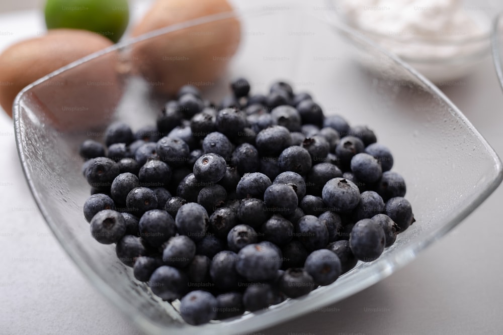 부엌 카운터에 있는 유리 그릇에 담긴 신선한 블루베리, 다이어트를 위한 건강 식품.