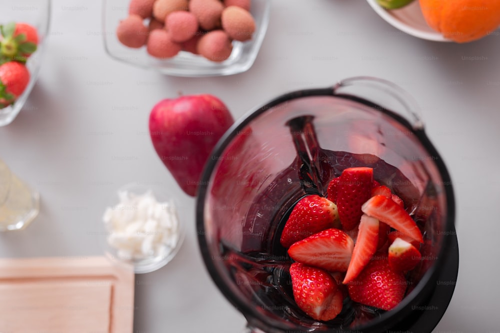 Rohe Erdbeeren in einem Mixer, um einen frischen hausgemachten Smoothie zuzubereiten. Konzept für einen gesunden Lebensstil