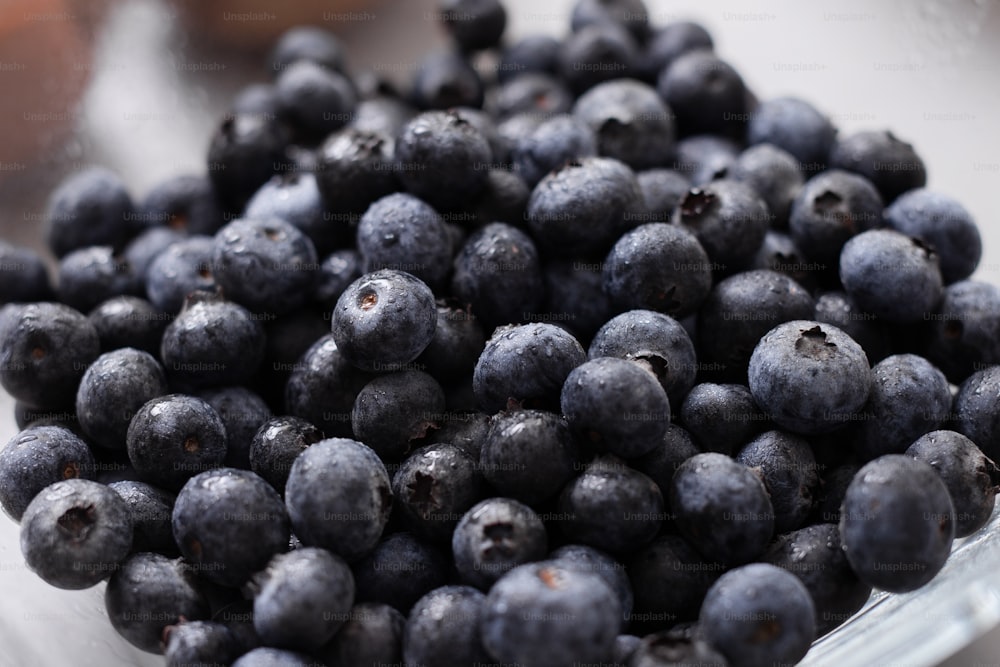 Fresh blueberries in a glass bowl on kitchen counter, healthy food for diet.