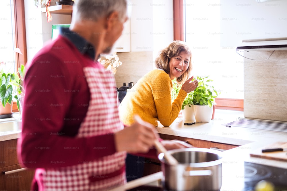 Älteres Ehepaar bereitet Essen in der Küche zu. Ein alter Mann und eine alte Frau im Haus.