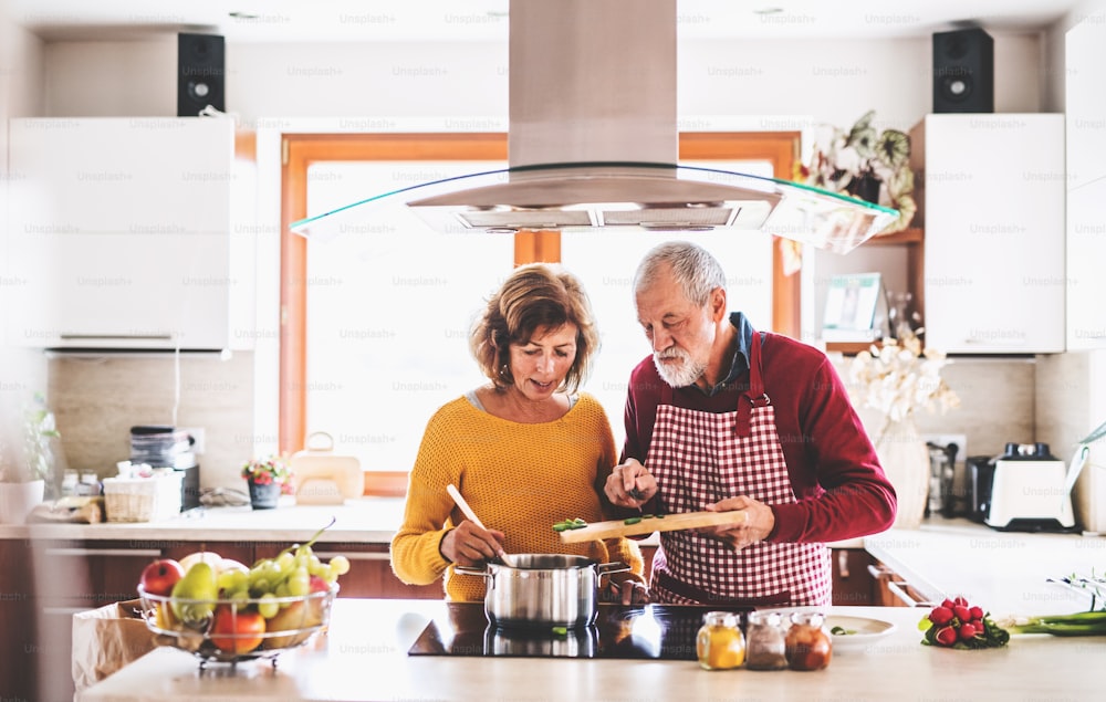 台所で食事を準備する老夫婦。家の中にいる老人と女性。