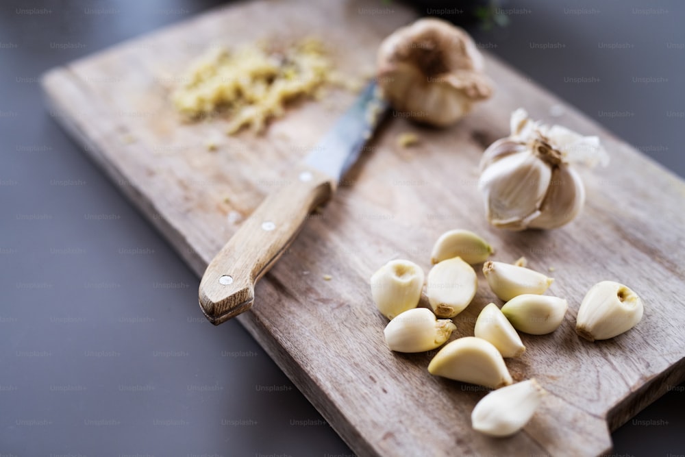 Garlic and knife on a wooden chopping board. Cooking concept.