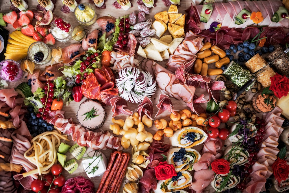 Una vista dall'alto di vari cibi e snack su un grande vassoio su una festa al coperto, un buffet freddo.