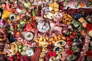 Une vue de dessus de divers aliments et collations sur un grand plateau lors d’une fête intérieure, un buffet froid.