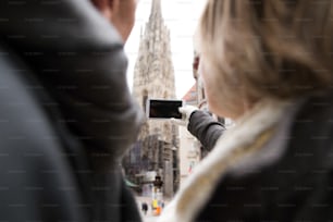Couple de personnes âgées méconnaissable lors d’une promenade dans le centre historique de la ville de Vienne, en Autriche. Femme prenant un selfie d’eux avec un téléphone intelligent. Hiver.