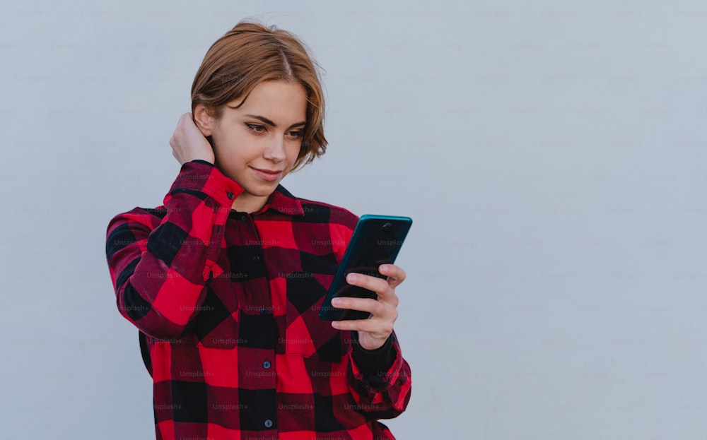 Junge Frau, die ein Selfie im Freien vor weißem Hintergrund macht, soial networks-Konzept.