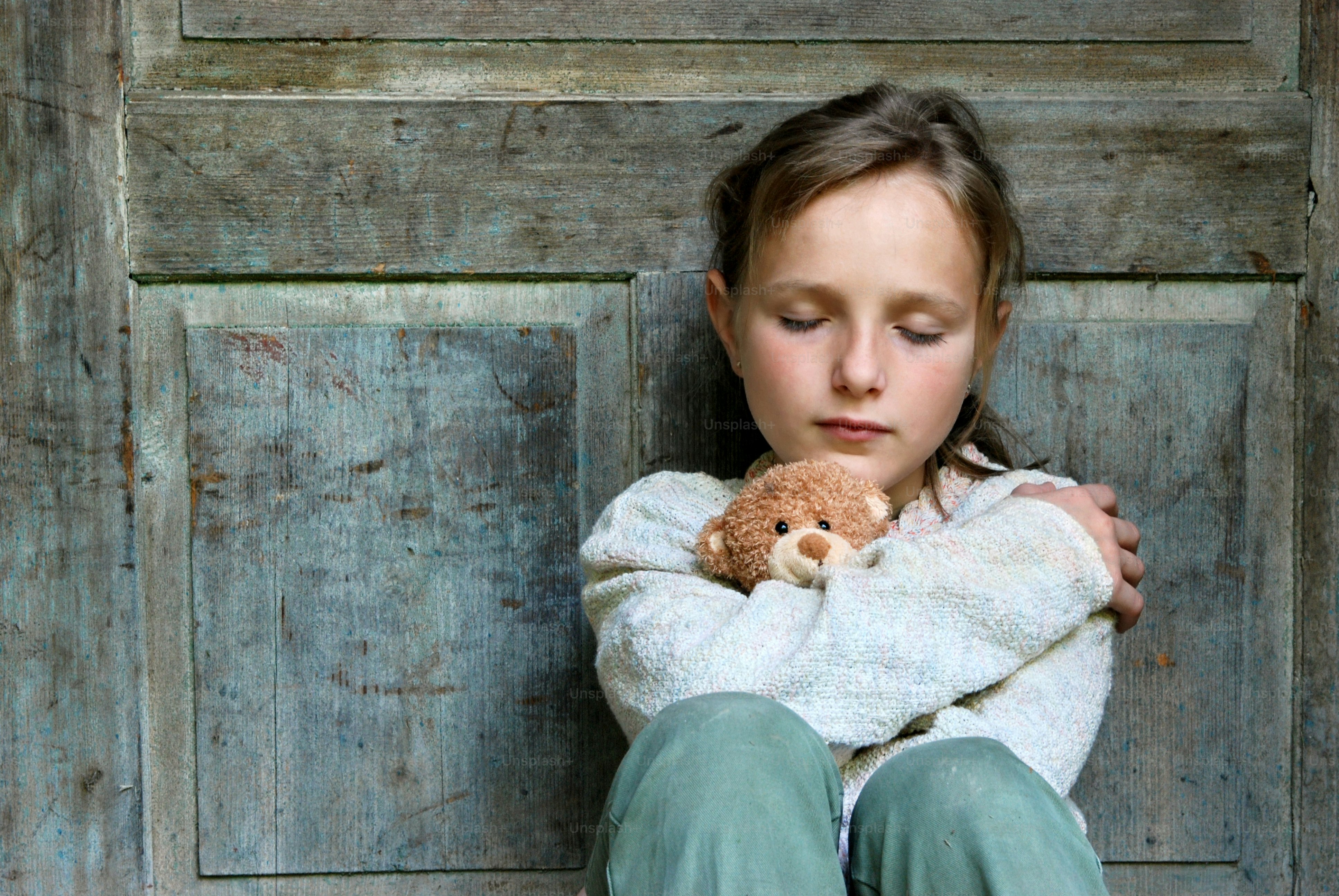 a young girl holding a teddy bear in her arms