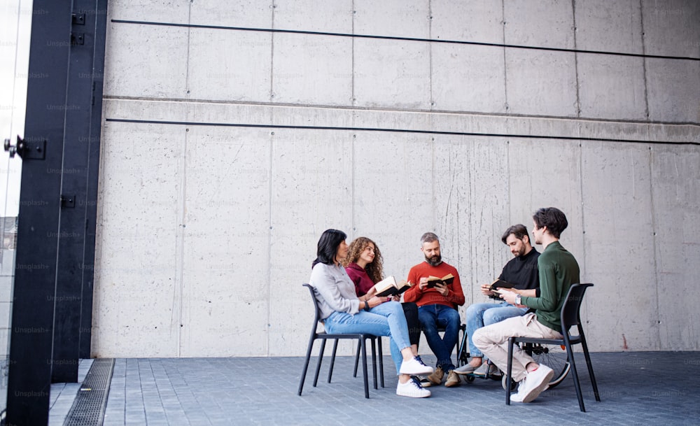 Men and women sitting in a circle during group therapy, reading and talking.