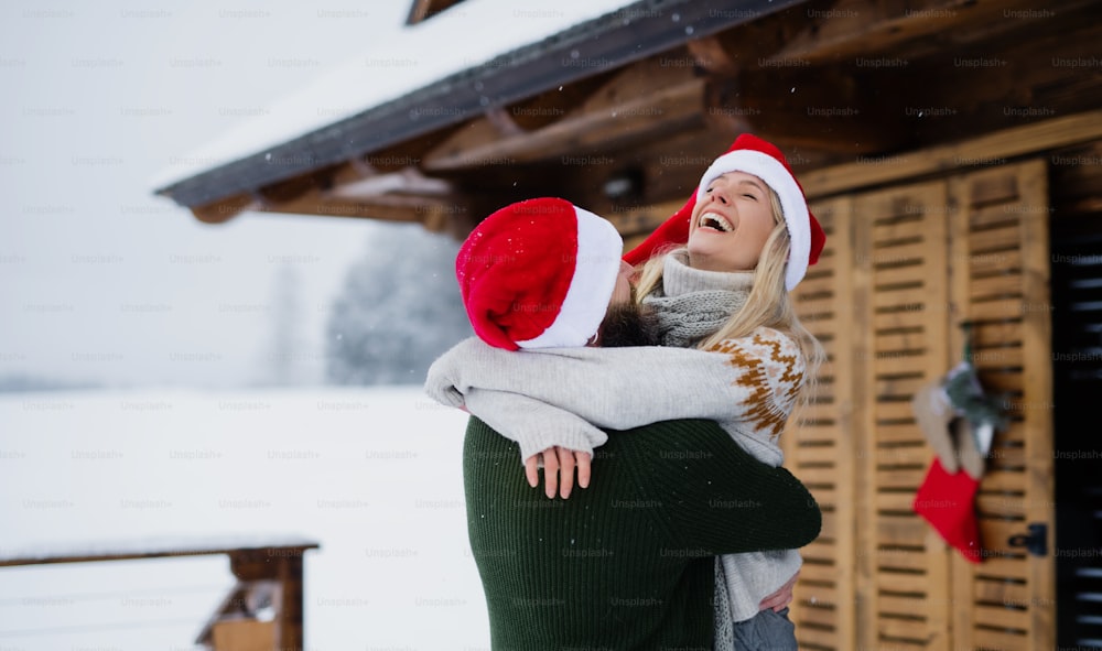冬の自然の中で屋外のテラスで楽しむ幸せな夫婦、クリスマスの時期に休日。