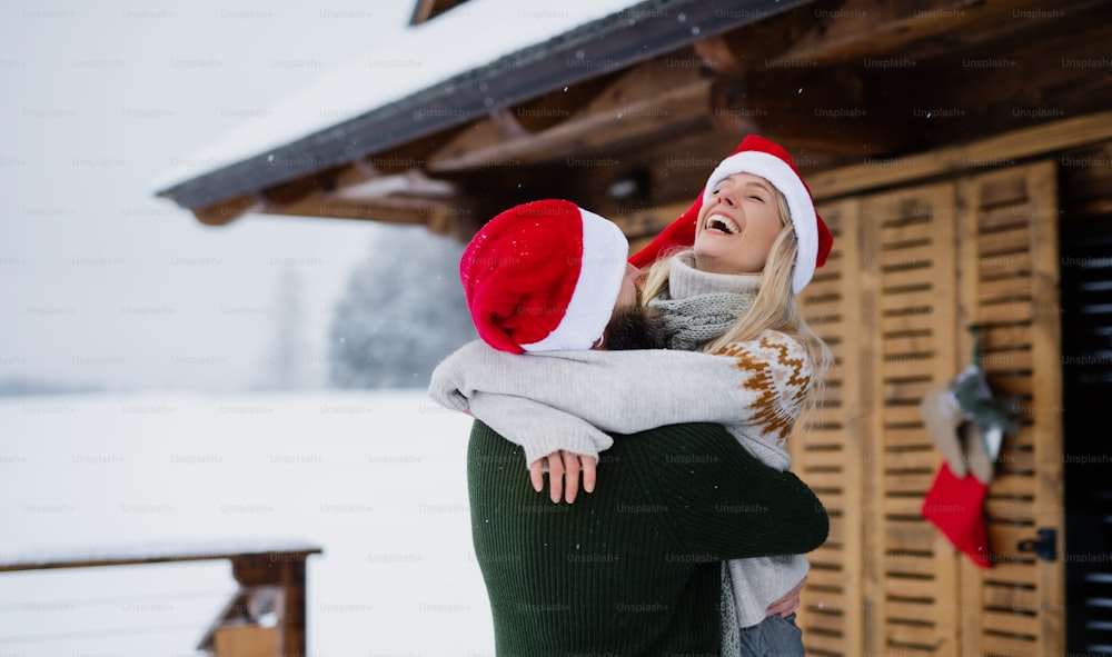 Happy couple having fun on a terrace outdoors in winter nature, holiday at Christmas time.