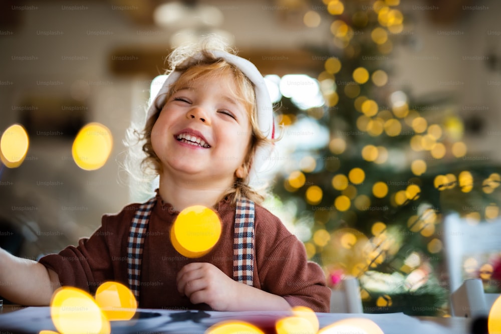 Porträt eines glücklichen kleinen Mädchens, das zu Weihnachten zu Hause ist und lacht.