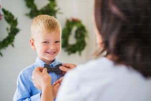 クリスマスの時期に家で小さな男の子に蝶ネクタイをしている認識できない祖母。