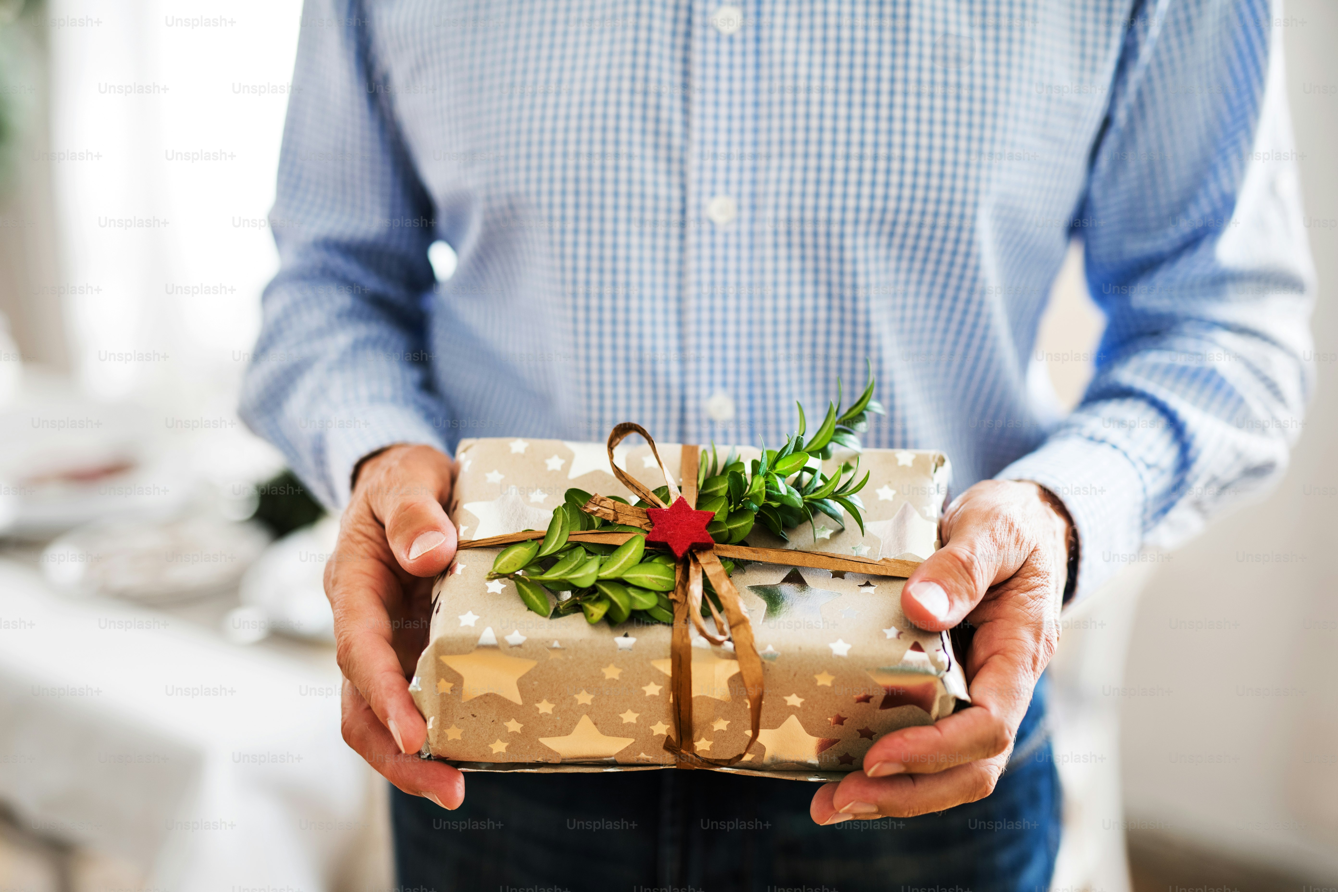 クリスマスの時期に包まれたプレゼントを持っている見覚えのない年配の男性。