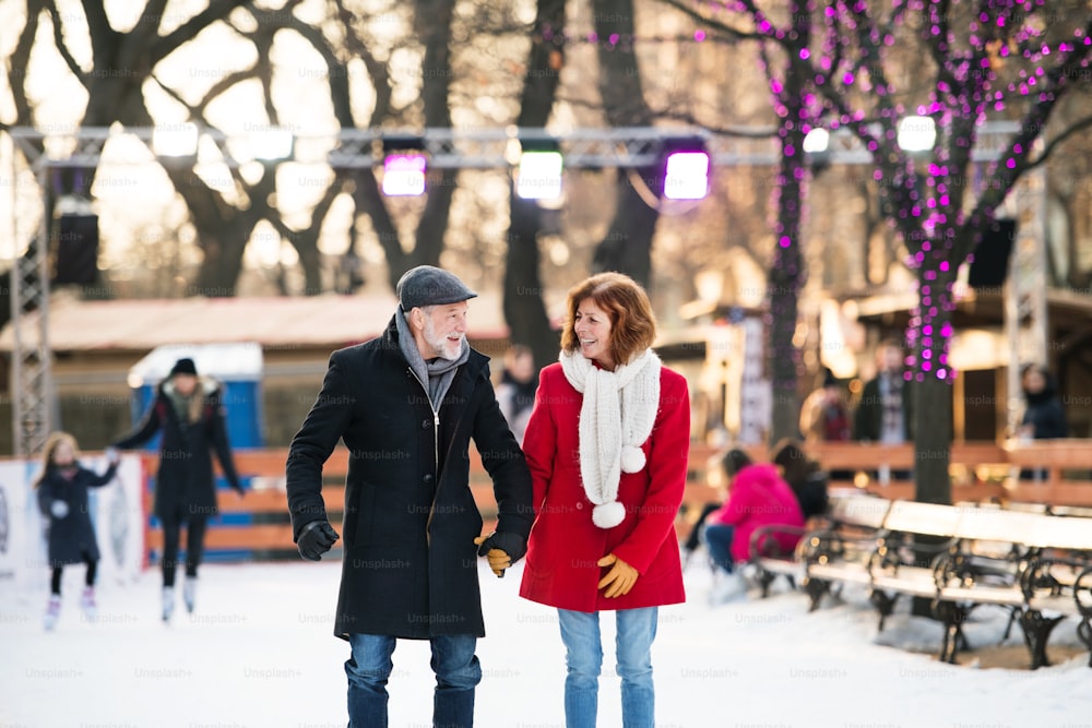 Heureux couple de personnes âgées lors d’une promenade dans une ville en hiver.