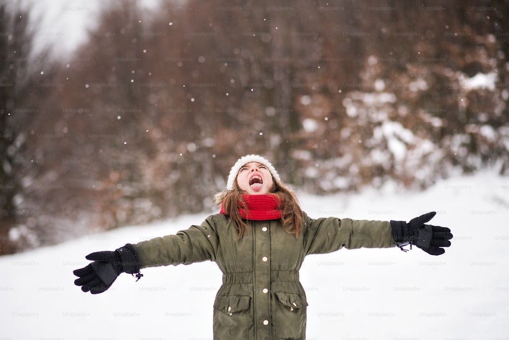 A small girl having fun in snow. Winter nature.