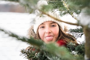 A small girl having fun in snow. Winter nature. Close up.