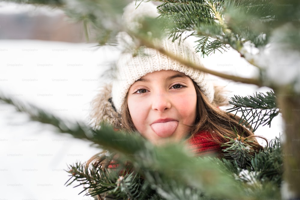 A small girl having fun in snow. Winter nature. Close up.