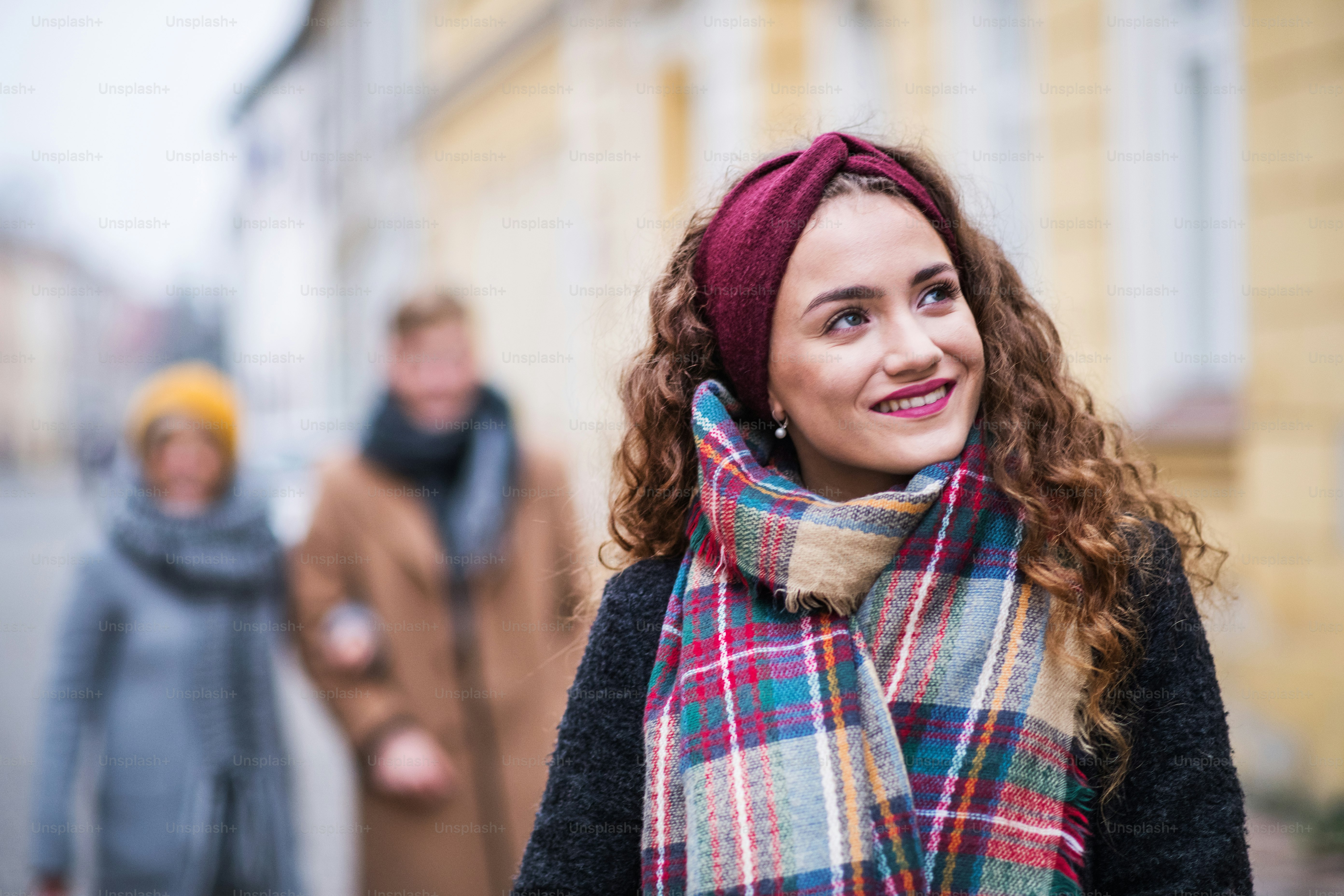 Portrait d’une adolescente avec bandeau et foulard debout dans la rue en hiver. Concept de shopping de Noël.