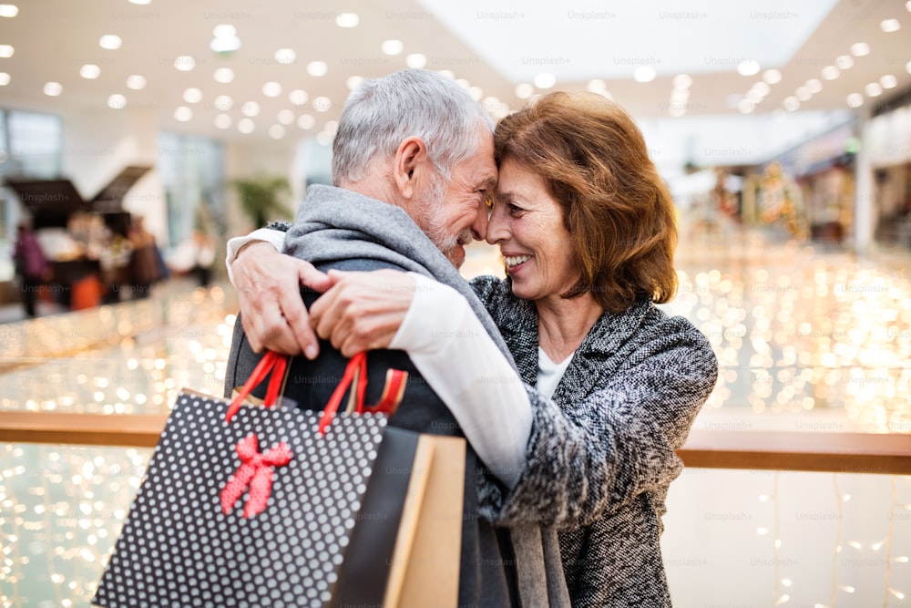 Älteres Paar beim Weihnachtseinkauf. Einkaufszentrum zur Weihnachtszeit.