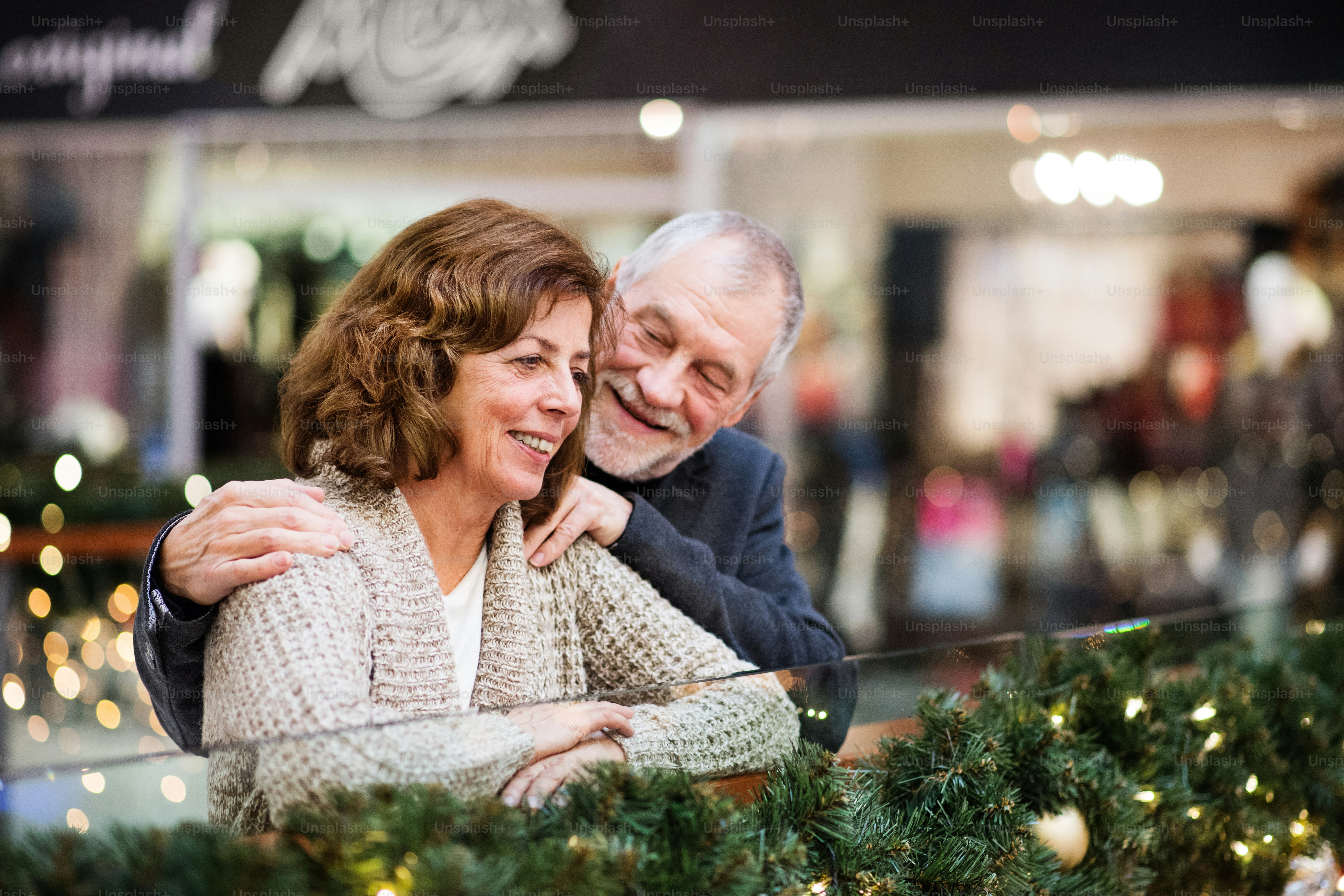 Couple de personnes âgées faisant des achats de Noël. Centre commercial au moment de Noël