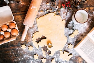 クリスマスの時期にジンジャーブレッドクッキーを焼く。木のテーブルの上の材料。ハイアングルビュー。