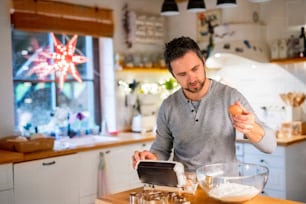 Man making cookies at home. Father baking gingerbread Christmas cookies, preparing the dough.