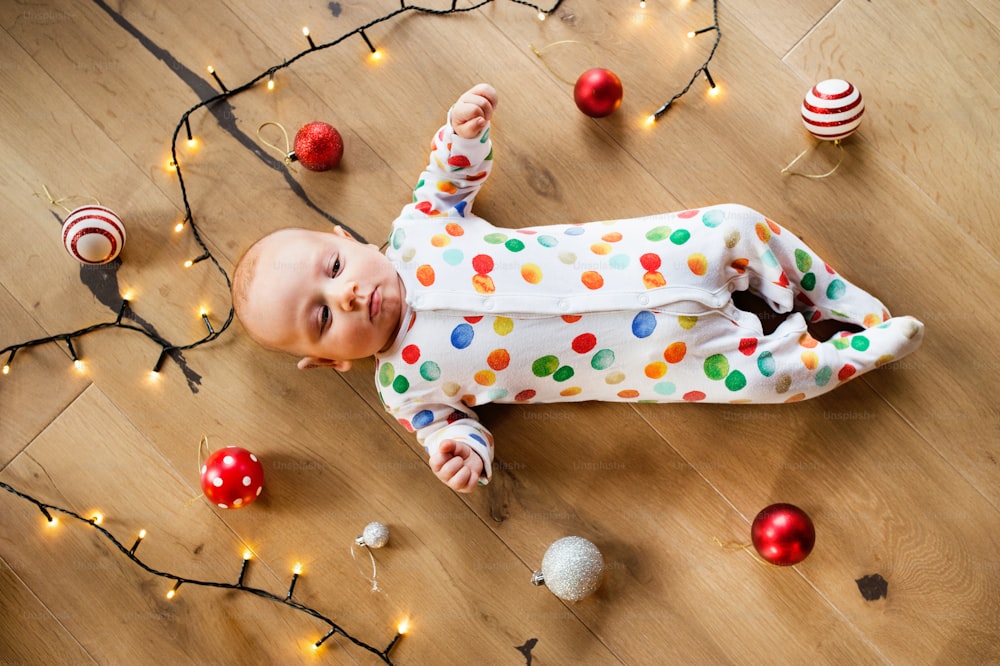 Little baby boy lying on the floor at Christmas time. High angle view.