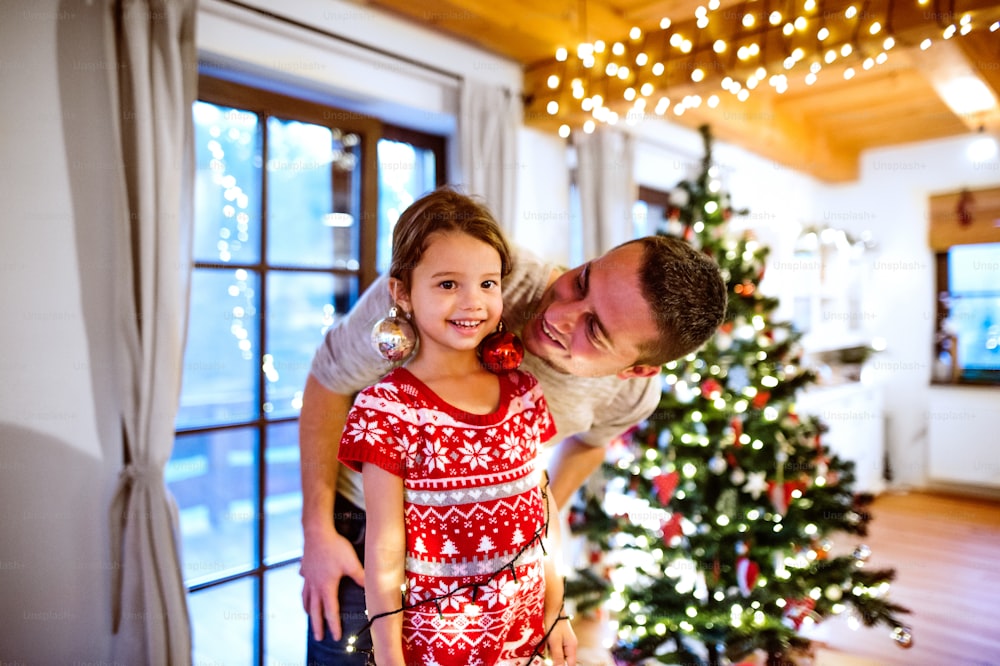 Young father with daughter having fun at Christmas time. Family enjoying Christmas.