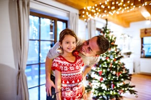 Young father with daughter having fun at Christmas time. Family enjoying Christmas.