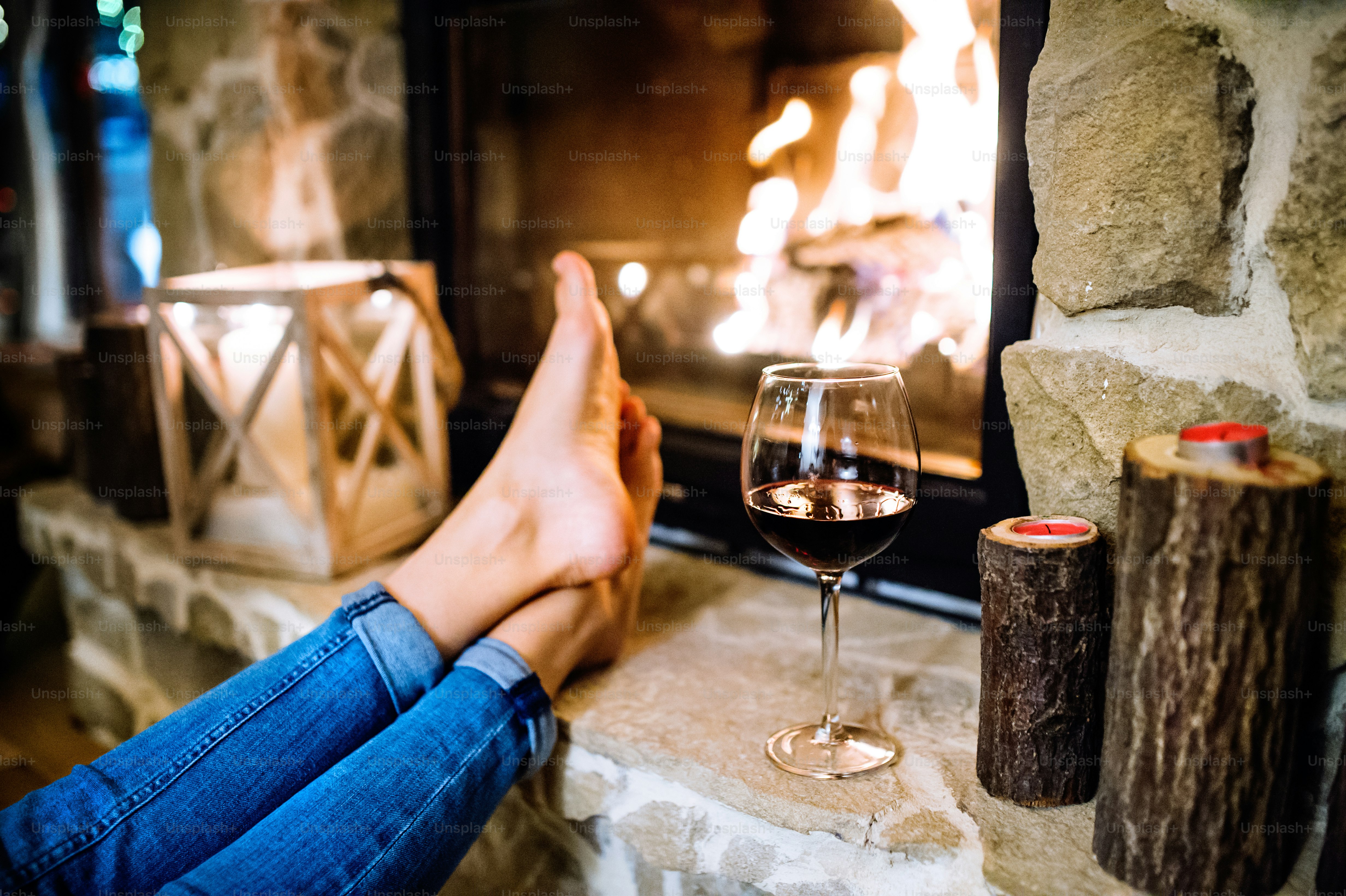 Feet of unrecognizable woman sitting in front of the fireplace, resting. Christmas time.