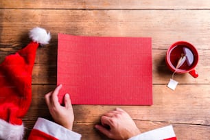 Der Weihnachtsmann hält eine leere Wunschliste in den Händen