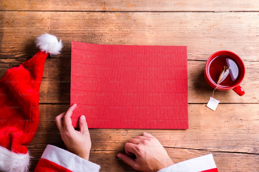 Santa Claus sosteniendo una lista de deseos vacía en sus manos