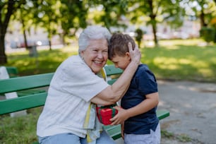 Um neto surpreendeu a avó com um presente de aniversário no parque. Estilo de vida, conceito de família