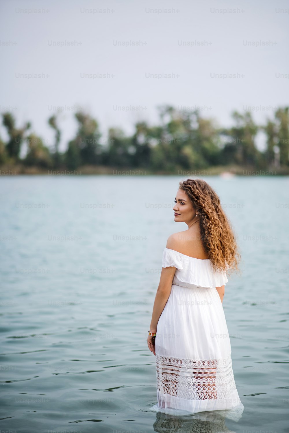 Young woman at summer festival, standing in lake. Copy space.