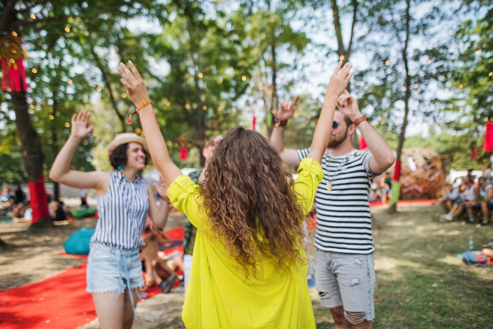 Groupe de jeunes amis joyeux dansant au festival d’été.