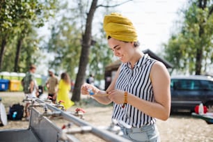 Young woman at summer festival, washing in the morning by basins.