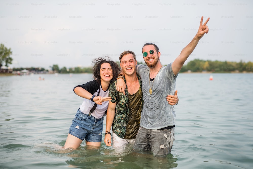 夏祭りの若い友達のグループで、湖の水の中に立つ。