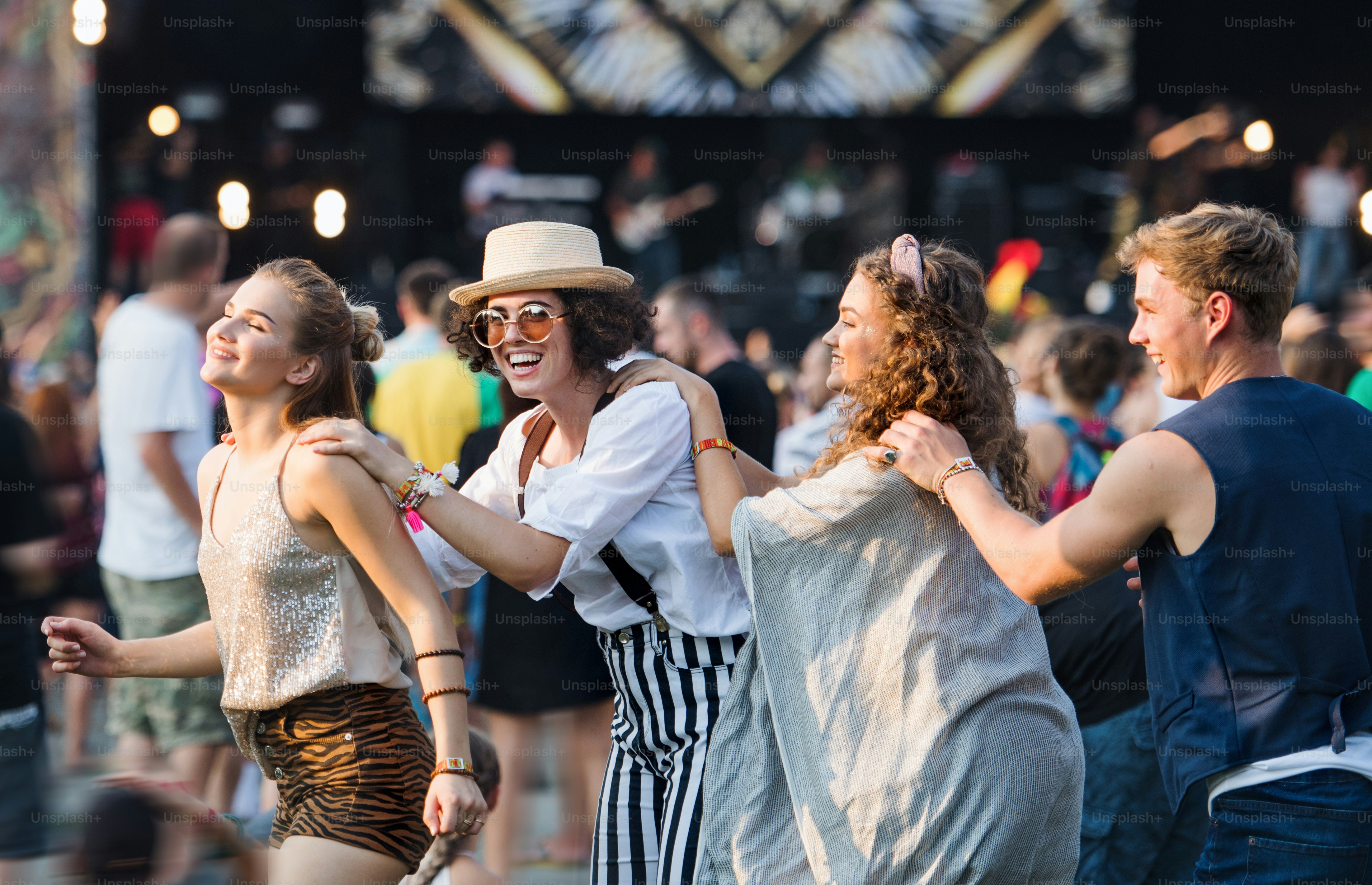 Grupo de jóvenes amigos alegres en el festival de verano, divirtiéndose.
