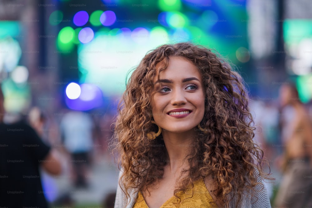 Portrait of beautiful young woman standing at summer festival.